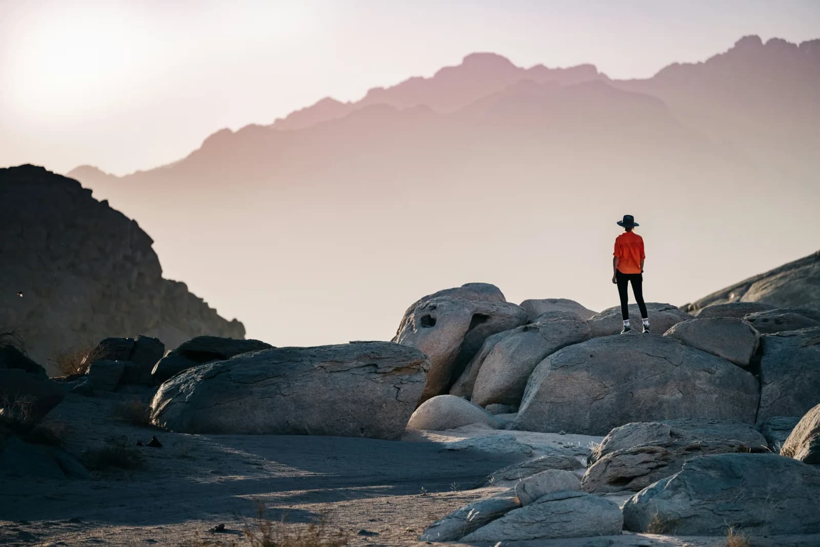 Person standing on big rocks looking at a mountain Employee Journey Mapping, employee journey