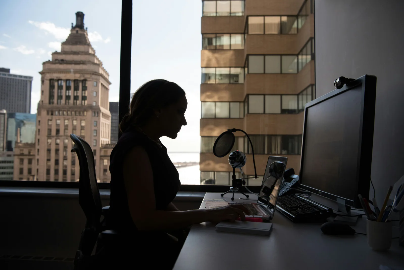 Women behind a desk on a laptop in front of a window European Pay Transparency Directive, eu pay transparency directive, Equal pay